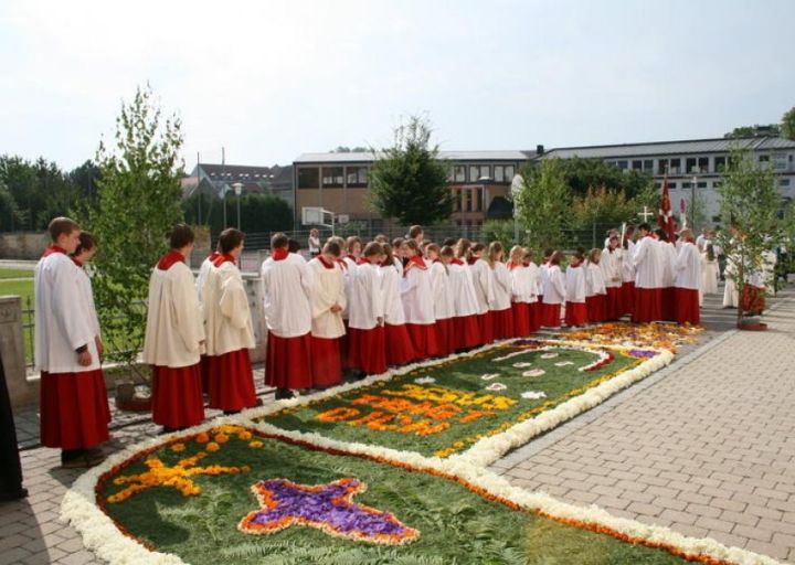 Prozession über einen Blumenteppich vor der Kirche