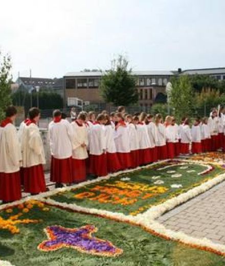 Prozession über einen Blumenteppich vor der Kirche